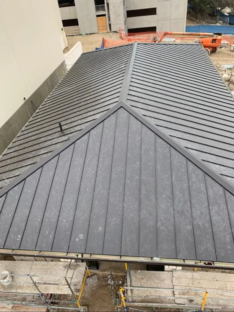 Commercial metal roof construction with crane equipment in St. Helens